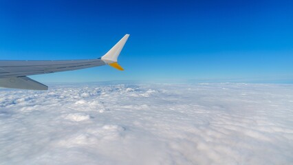 Stunning aerial view from an airplane window, featuring the aircraft s wing gliding above a sea of...