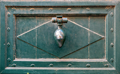 Historic iron door knocker in the shape of a cone on a house door  in Toulouse, France
