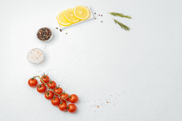 Fresh cooking ingredients tomatoes lemon pepper rosemary salt on white table