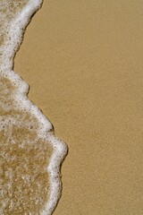 Experience the serene beauty of a pristine beach where golden sand meets gentle waves. This coastal scene captures tranquility, perfect for tourism and relaxation themes. © Ilja