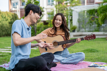 Asian young couple spend time on romantic date outdoors at the garden. 