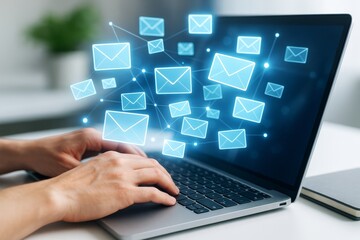 Obraz premium Person typing on laptop with glowing email icons floating in the air representing digital communication and technology concept on blurred background.
