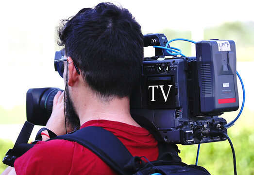 Grabando plano en programa de noticias e informaci&oacute;n tipo reportaje period&iacute;stico de TV con c&aacute;mara profesional al hombro