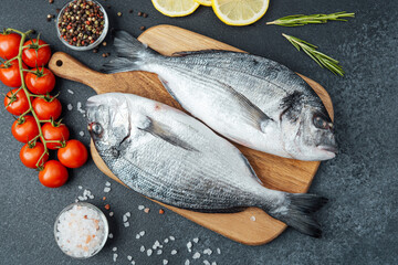 Dorado  fish with  tomatoes,  lemon and spices on cutting board