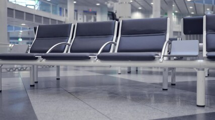 This is a closeup view showcasing the sleek, modern airport seating nestled within a spacious and welllit terminal area. This setting is ideal for themes related to travel and airport experiences