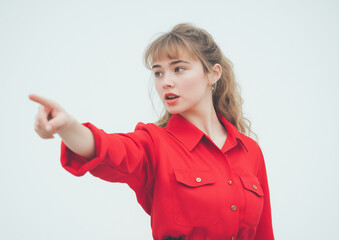 Young Woman in Red Shirt Pointing at Empty Space – High-Quality Stock Photo with Professional Color Grading, Minimal Contrast, and Clean, Sharp Focus on White Background
