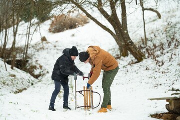 A father and son team up to assemble a wooden sled in a snowy winter wonderland. Shared moments and...