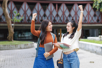 Two happy students celebrating success on campus