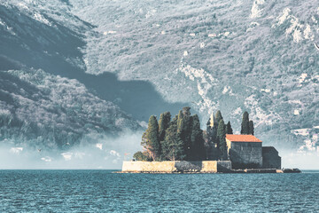 St. George Monastery on islet at sunrise with dramatic mountain shadows in Kotor Bay, Montenegro