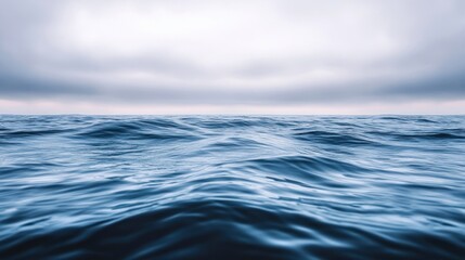 Obraz premium Ocean waves under a cloudy sky, calming blue