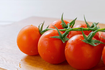 Fresh cherry tomatoes on a cutting board. まな板の上の新鮮なミニトマト