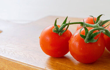 Fresh cherry tomatoes on a cutting board. まな板の上の新鮮なミニトマト