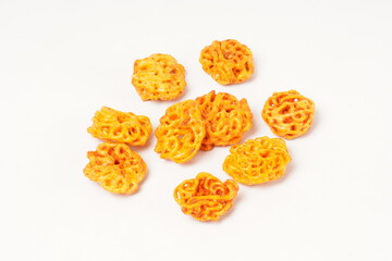 A pile of spicy Indonesian crackers or Kerupuk with spiral twists, coated in red-orange chili powder and rich spices. Bold, flavorful, and appetite-boosting. Photographed against a white background.