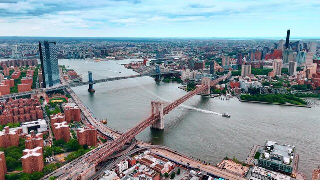 Fast moving transport on the roads along the East River in New York. Aerial perspective on the Brooklyn Bridge and the Manhattan Bridge.