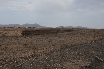 volcanic arid landscapes with trils, cliffs, and scattedred vegetation.