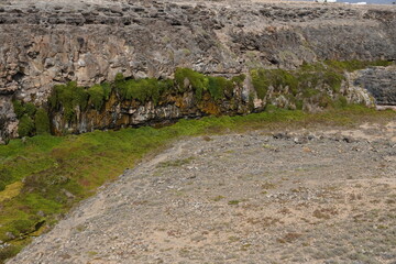volcanic arid landscapes with trils, cliffs, and scattedred vegetation.