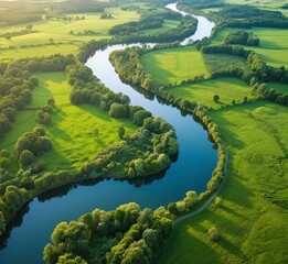 Drone View of Serpentine River Winding Through Lush Countryside and Green Fields