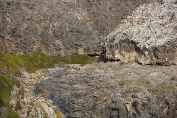 volcanic arid landscapes with trils, cliffs, and scattedred vegetation.