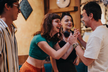 A joyful group of friends interacts with laughter and smiles at a social event. The lively atmosphere reflects friendship, happiness, and connection among young adults at a casual indoor gathering.