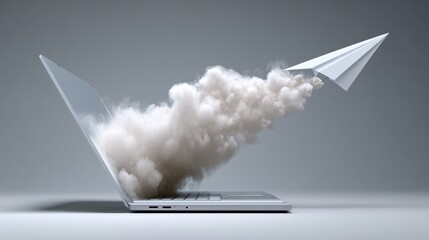 Laptop is opened to reveal a white paper airplane flying through a cloud of smoke. Concept of creativity and imagination, as the paper airplane represents the idea of flight