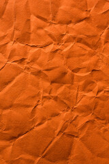 Wrinkled and crumpled orange tissue wrapping paper.