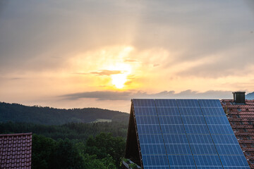 Clean solar energy from rooftop panels on a residential building shining in warm evening sunlight