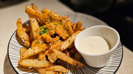 Enjoying crispy French fries with truffle, salted egg yolk sauce, mayonnaise bistro bar restaurant— late-night snack fast food cocktails, nightlife vibe, black background, white table, glowing light
