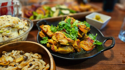 Delicious masala spiced curry grilled chicken with cilantro — Indian tandoori roasted dish with flavorful marinade, served on a black ceramic plate