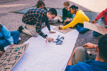 Young activists preparing protest banner for climate change demonstration