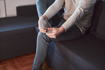 Man with ankle and foot pain at home.