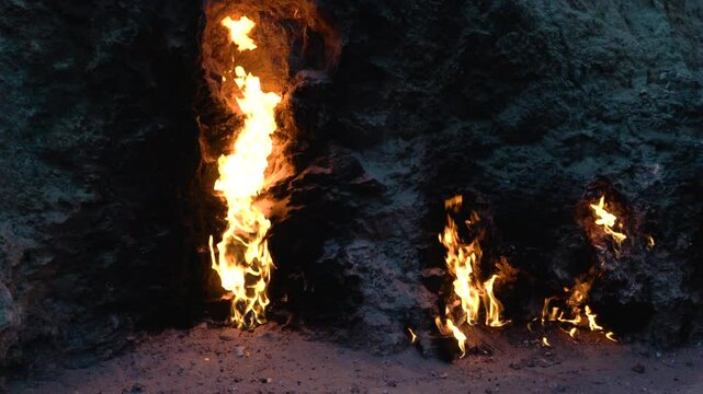 handheld close up of fire burning naturally from a mountain at Gobustan