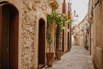 Charming narrow street in Syracuse, Sicily, with baroque stone buildings and Mediterranean character
