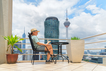 Woman is reading a book at scenic terrace among skyscrapers