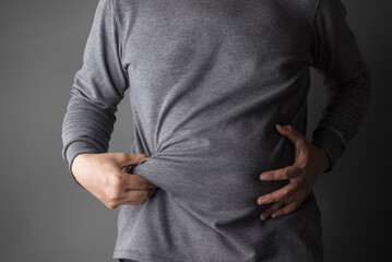 overweight or obese old man shows fat deposits in the abdomen. healthcare, medicine concept.