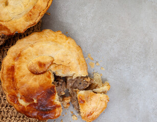 pepper steak pie with fresh flaky crust on grey with copy space
