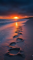 Sunset on the beach with the sun reflecting in the water and footprints in the sand. Suitable for travel blogs and articles about travel.