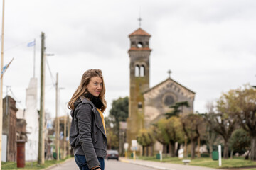 Woman standing on quiet street with historic church behind