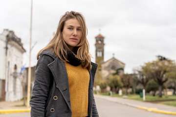 Woman standing on quiet street with historic church behind