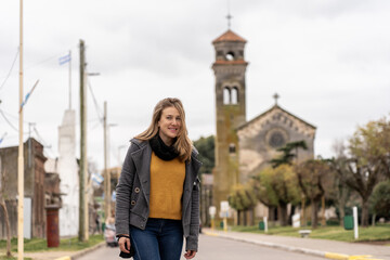 Woman standing on quiet street with historic church behind