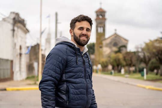 Man smiling on street with historic church in background - Powered by Adobe