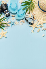 Summer accessories creating a frame on light blue background with copy space