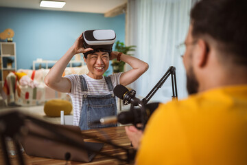 Excited japanese woman wear virtual goggles at home studio
