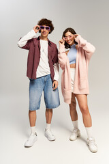 Fototapeta premium Stylish young couple enjoying a playful moment in trendy summer fashion