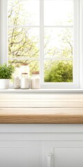 Fototapeta premium Modern empty kitchen countertop with natural light and plant vase, perfect for product display.