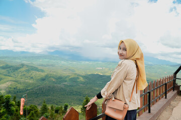 Young woman in hijab enjoying a scenic mountain vista.