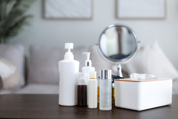 Beauty products and mirror resting on wooden table in living room