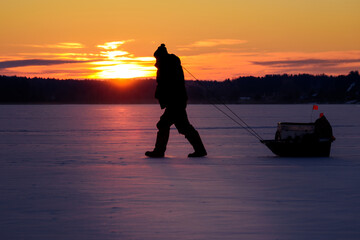 Brutal Ice Fisherman with Sled — Horizontal Winter Scene on Frozen Forest Lake