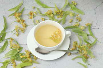cup of herbal tea with linden flowers on wooden background