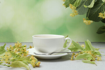 cup of herbal tea with linden flowers on wooden background