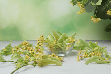 cup of herbal tea with linden flowers on wooden background